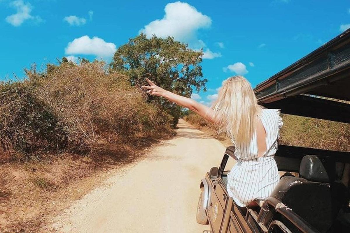 một người phụ nữ đang đi trên một chiếc xe trên một con đường đất