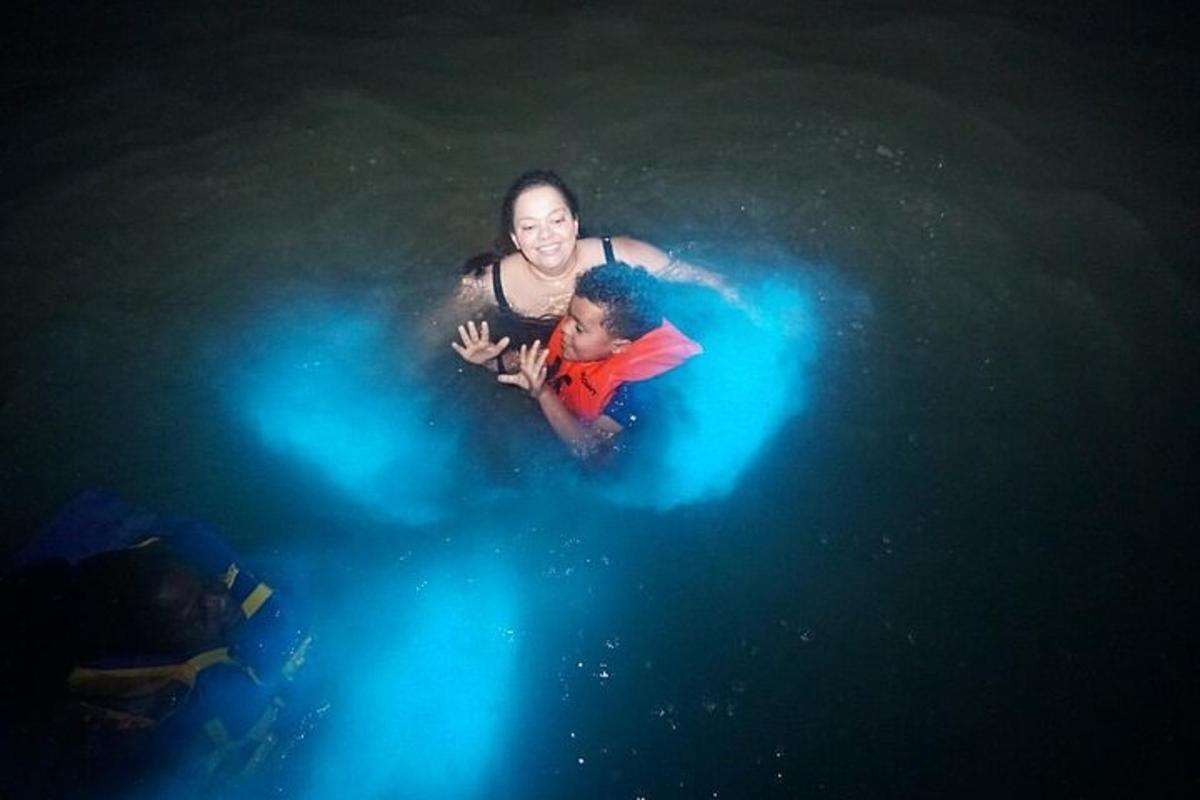 Una mujer y un niño en el agua con luces.