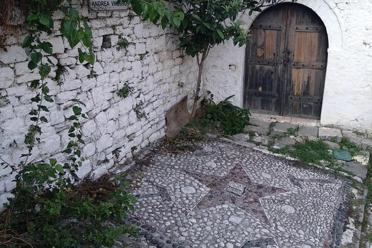 ένα κτίριο με ξύλινη πόρτα και πέτρινο διάδρομο