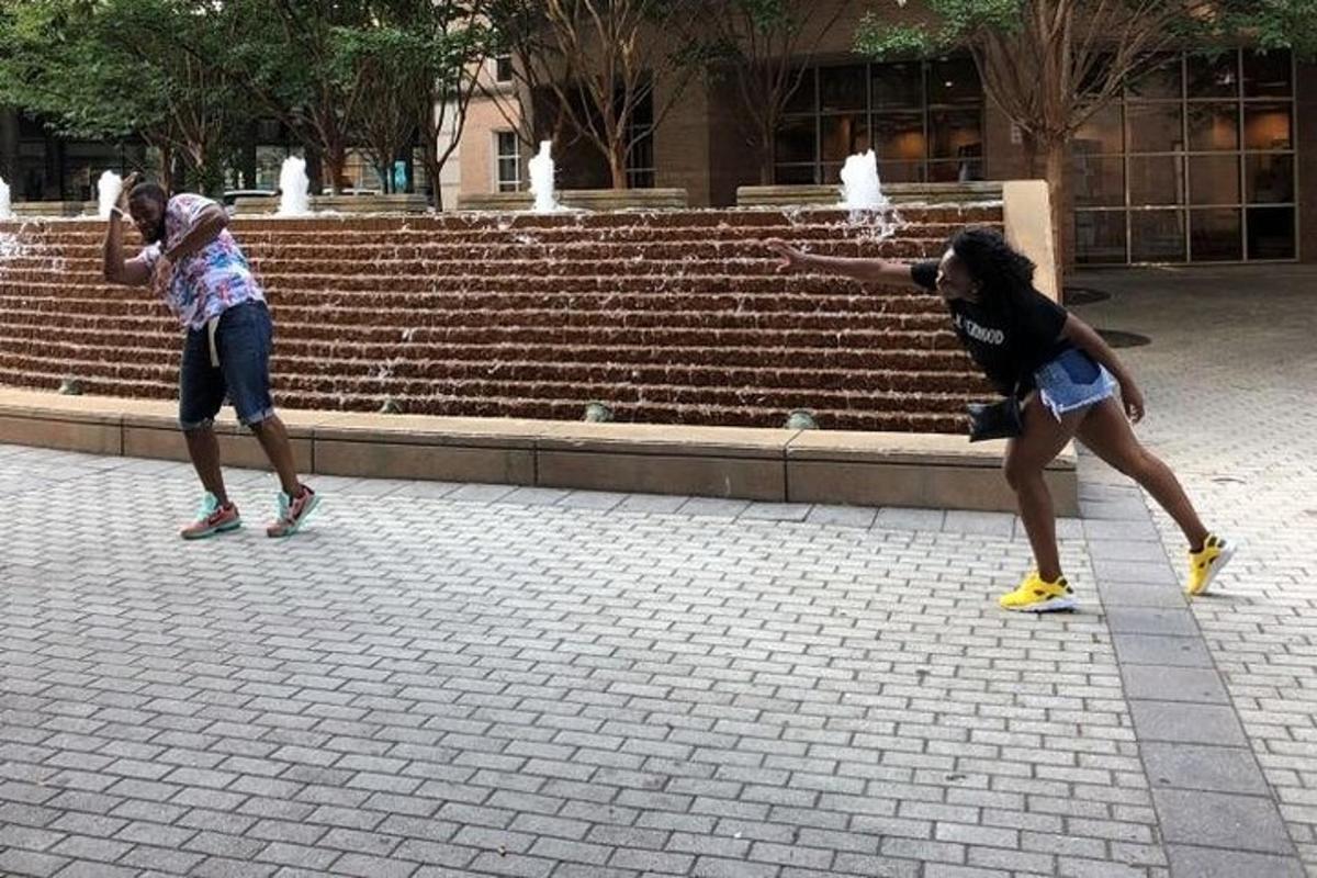 Dos niñas jugando al frisbee frente a una fuente