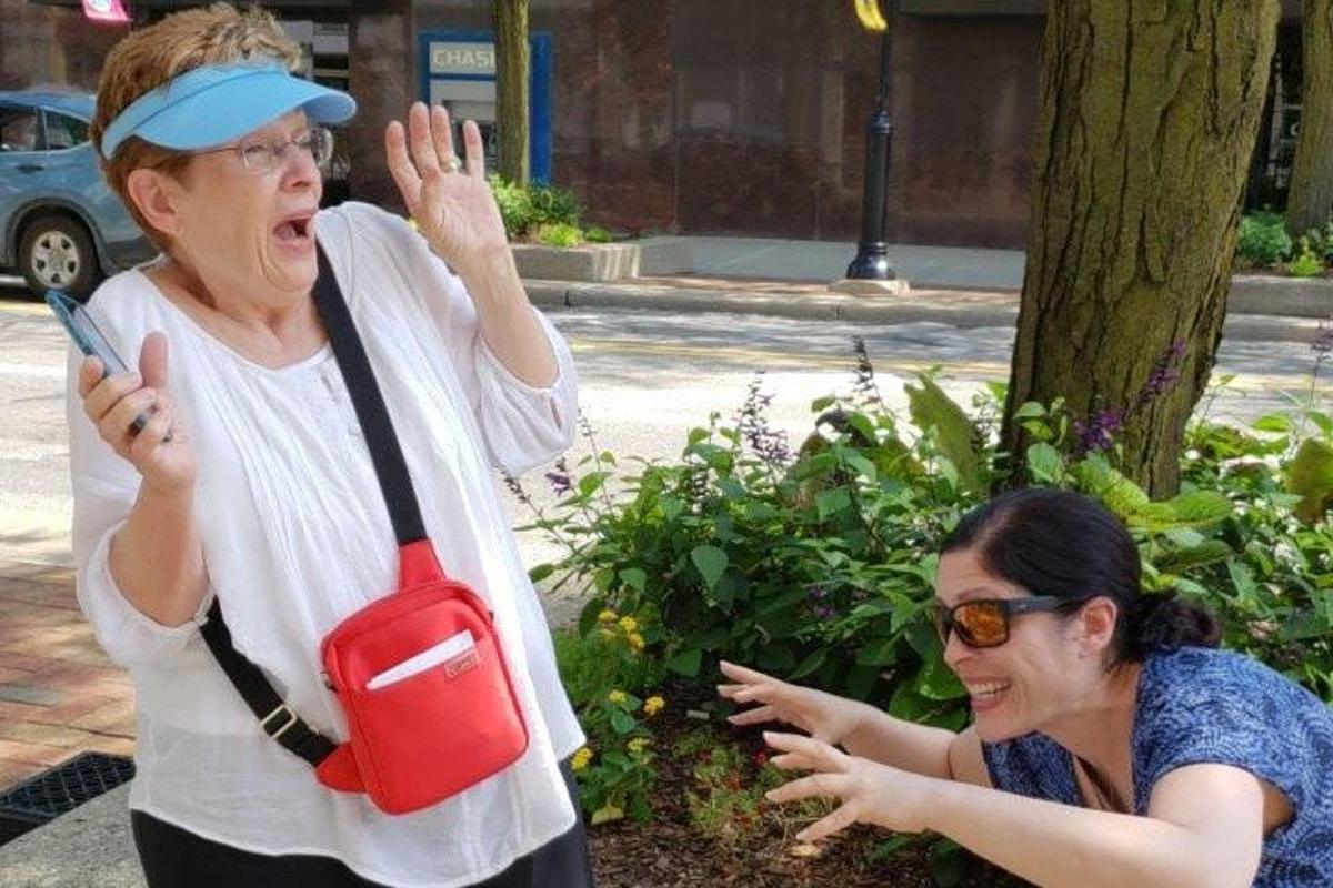 žena stojící vedle ženy držící červenou kabelku