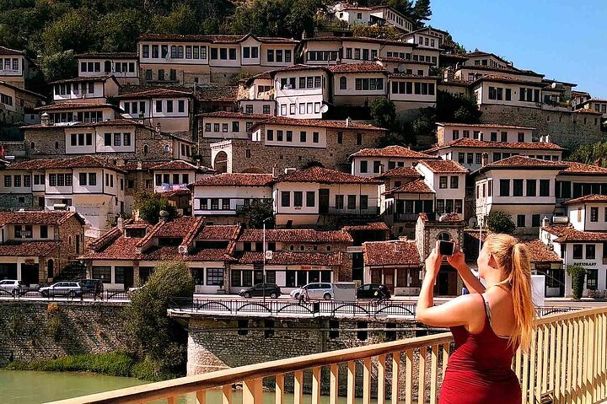 uma mulher tirando uma foto de uma montanha