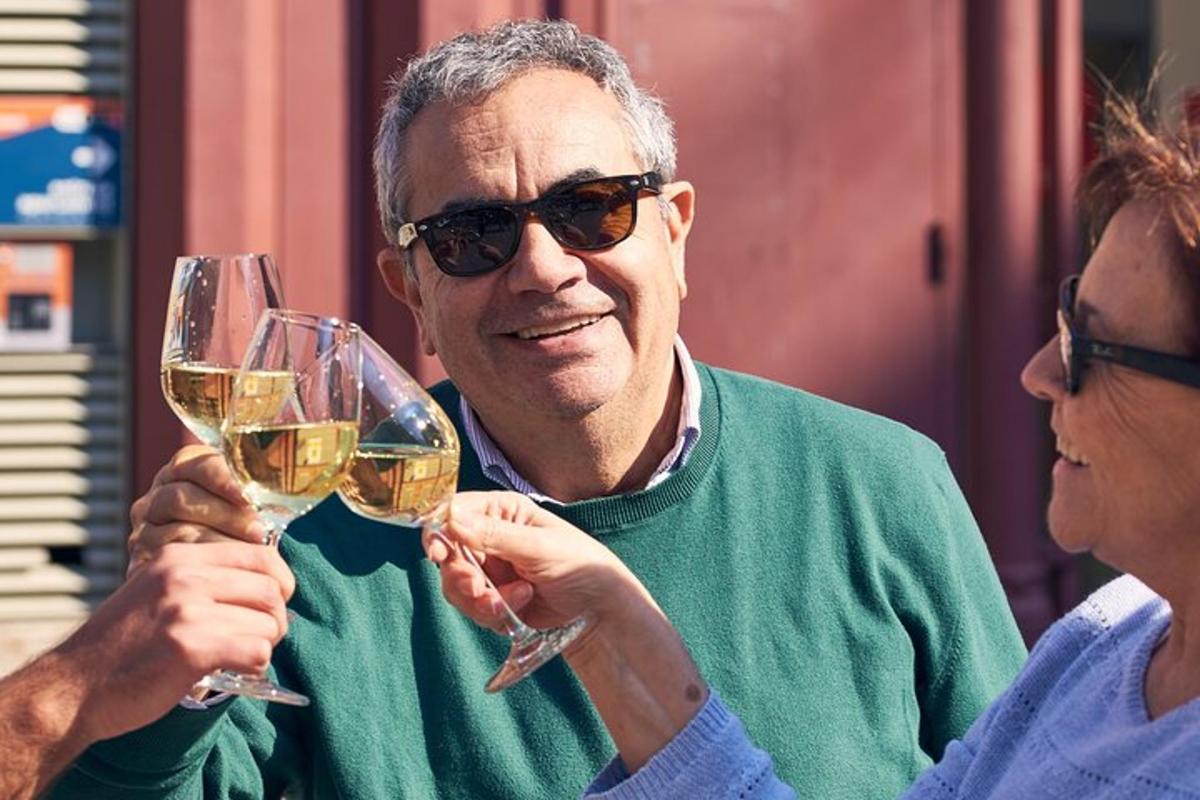 due persone che tengono in mano bicchieri di vino bianco