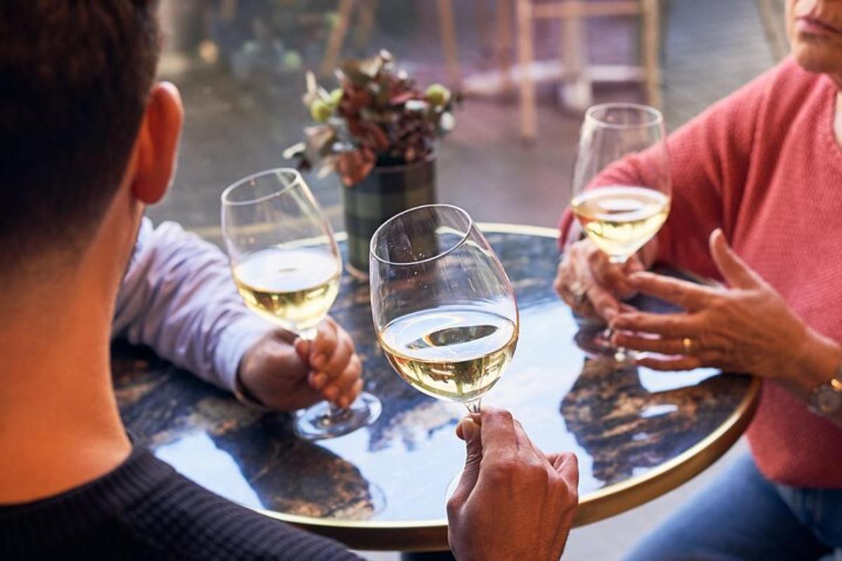 um grupo de pessoas sentadas ao redor de uma mesa bebendo vinho
