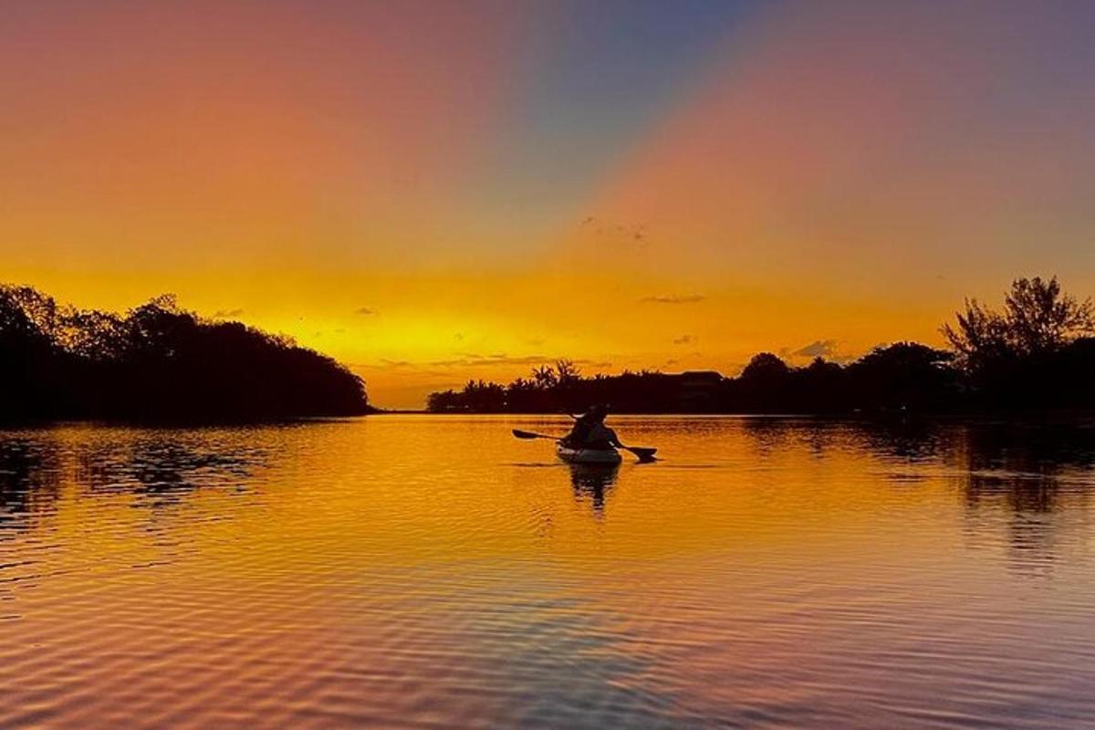 seseorang di dalam bot di tasik pada waktu matahari terbenam