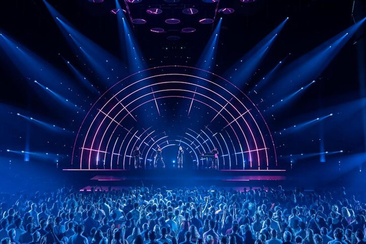 an audience watching a stage with blue and purple lights