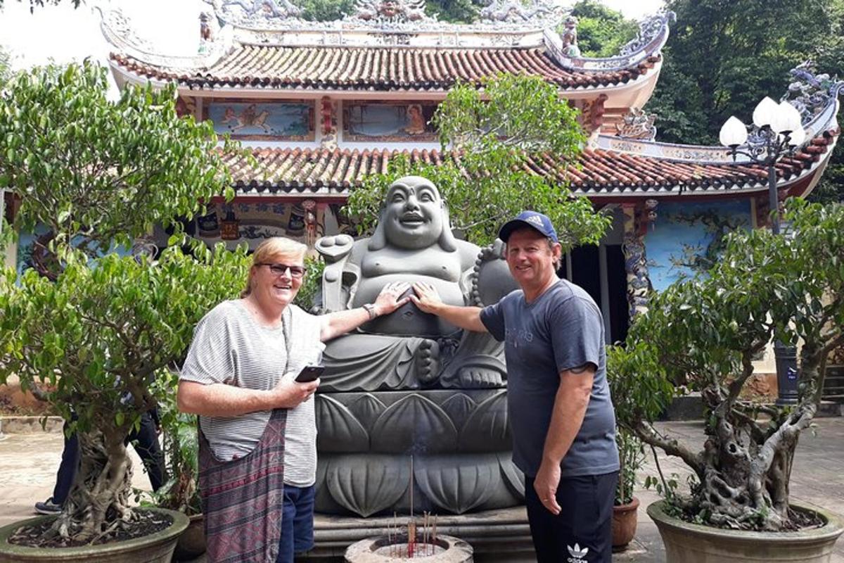 two men standing in front of a statue in front of a building