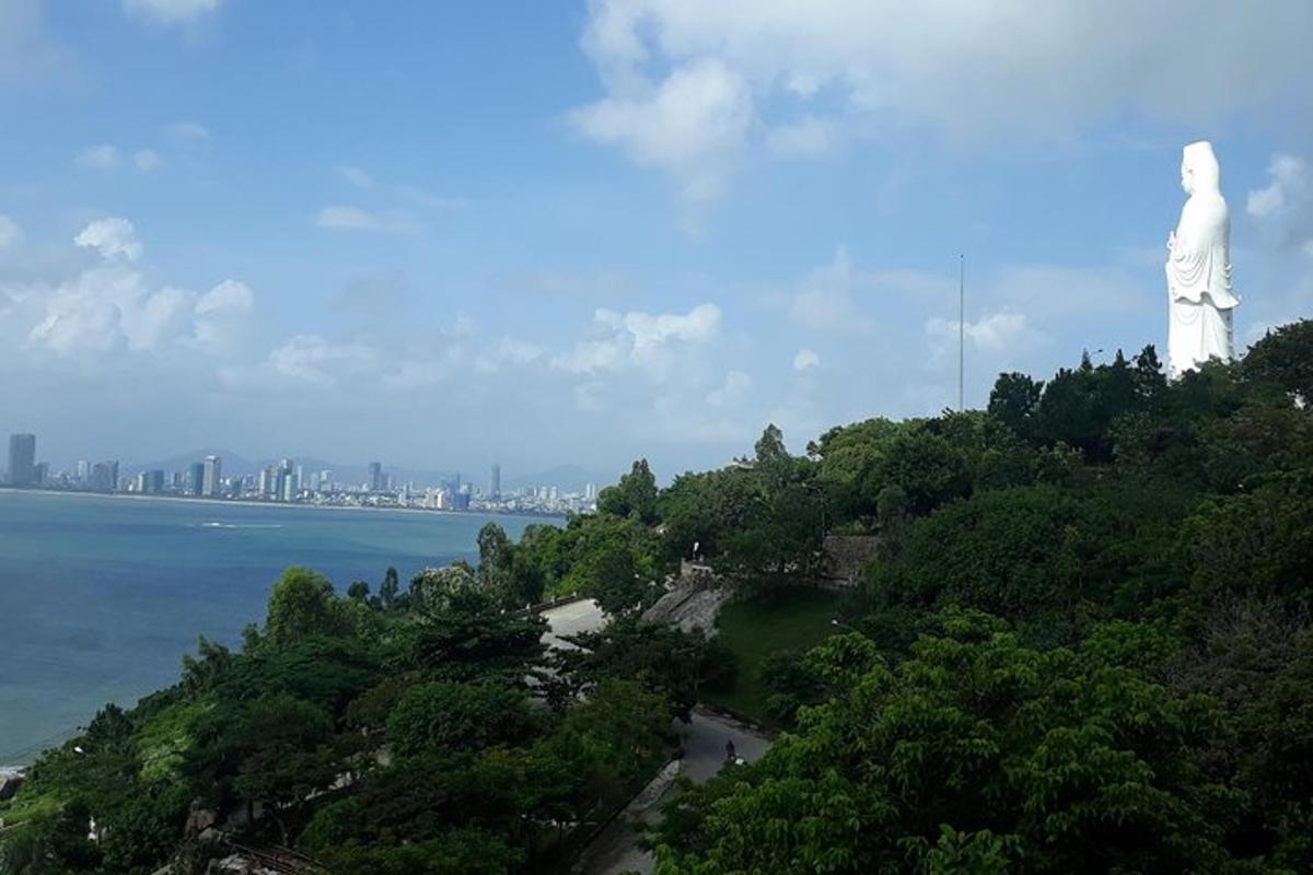 a statue on top of a hill next to the water