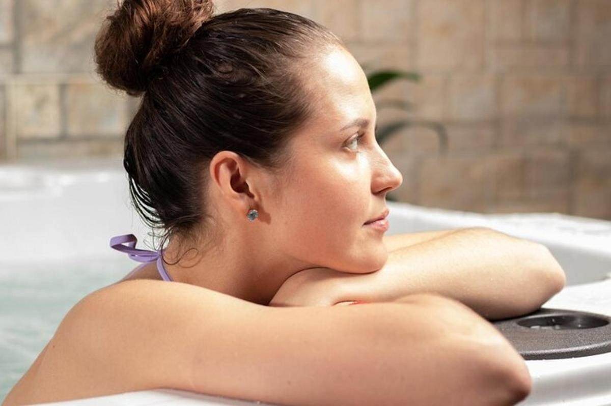 seorang wanita duduk di dalam tab mandi dengan tangan bersilang