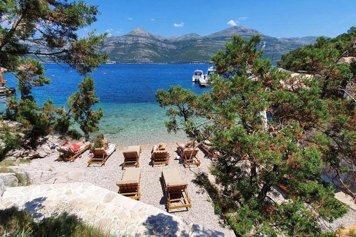 plaža z ležalniki in čolnom v vodi