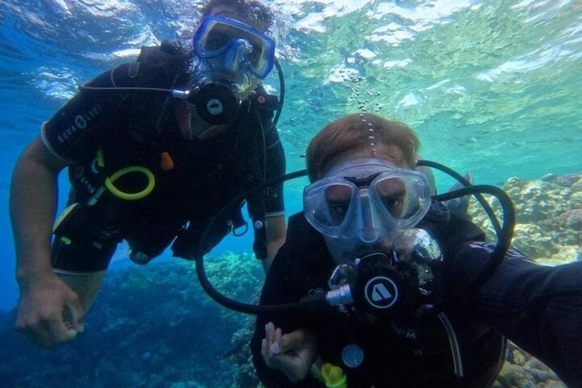 Dos personas con equipo de buceo en el agua