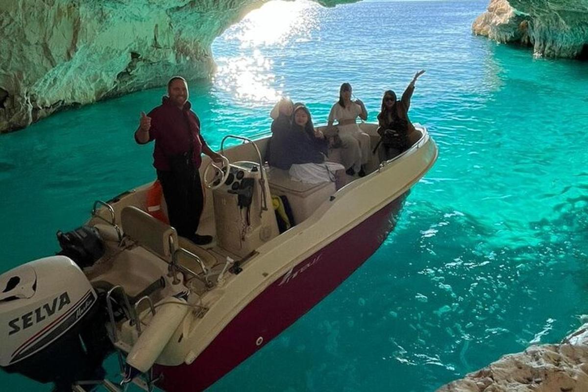 un grup de oameni pe o barcă în fața unei peșteri