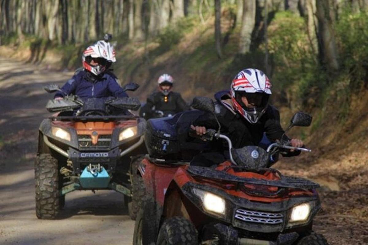 tres persones que viatgen en quads per un camí de terra