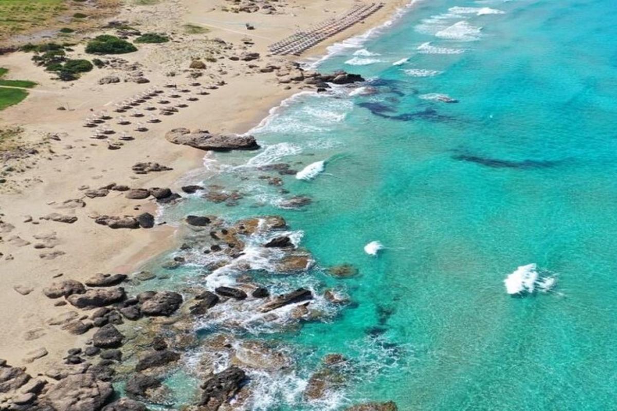 an aerial view of a beach with rocks and water