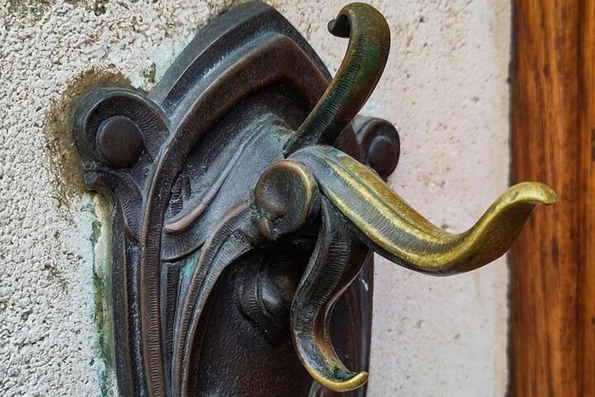 uma maçaneta de porta de metal com uma cobra nela