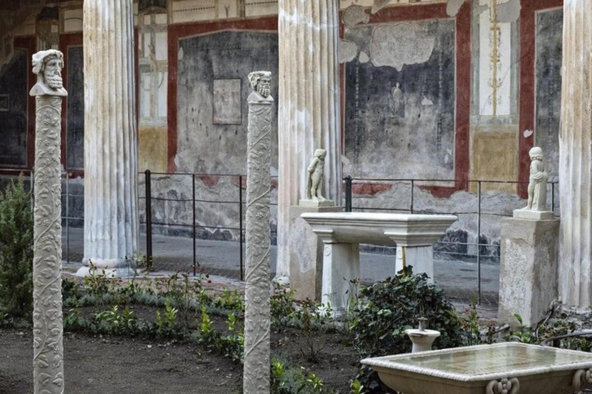 ένα κτίριο με κίονες και ένα σιντριβάνι σε μια αυλή
