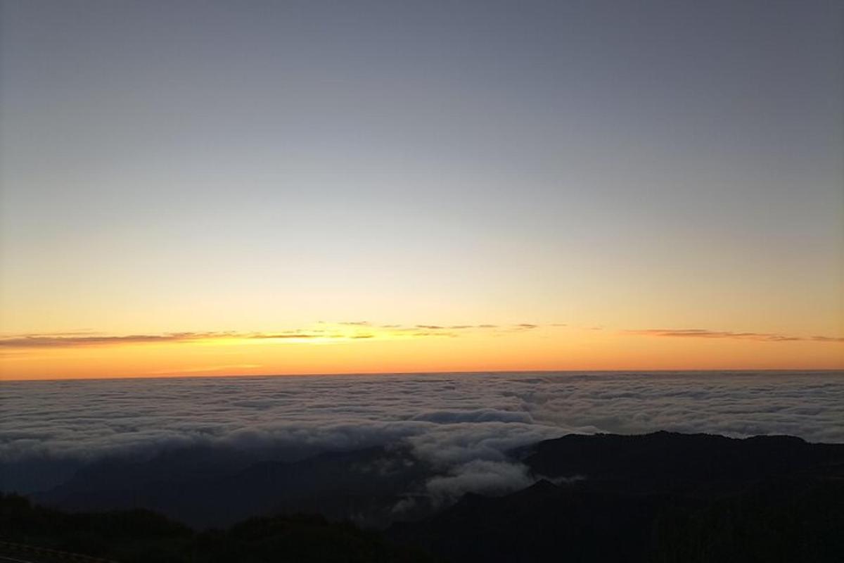 uma vista do pôr do sol acima das nuvens
