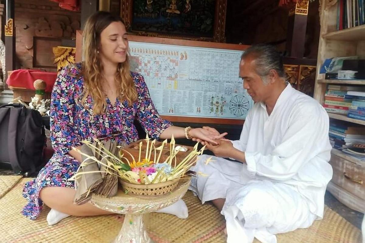 a man and a woman sitting on the floor with a basket of candles