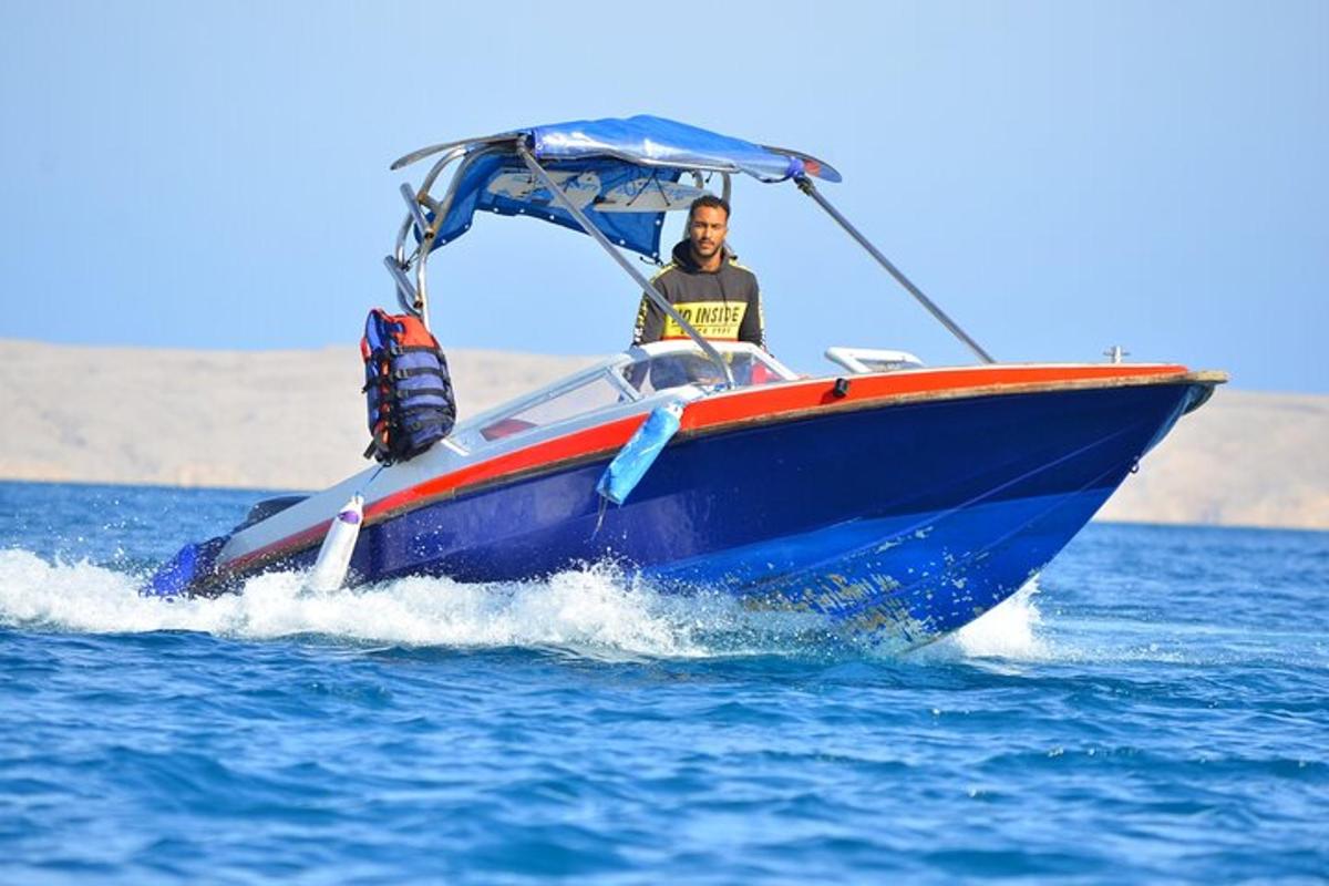 một người đàn ông trên chiếc thuyền màu xanh trong nước