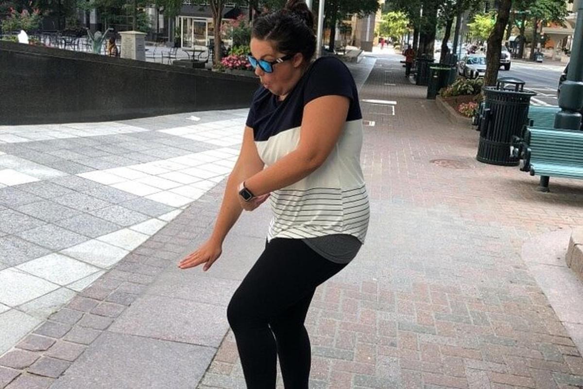 žena jedoucí na skateboardu po chodníku