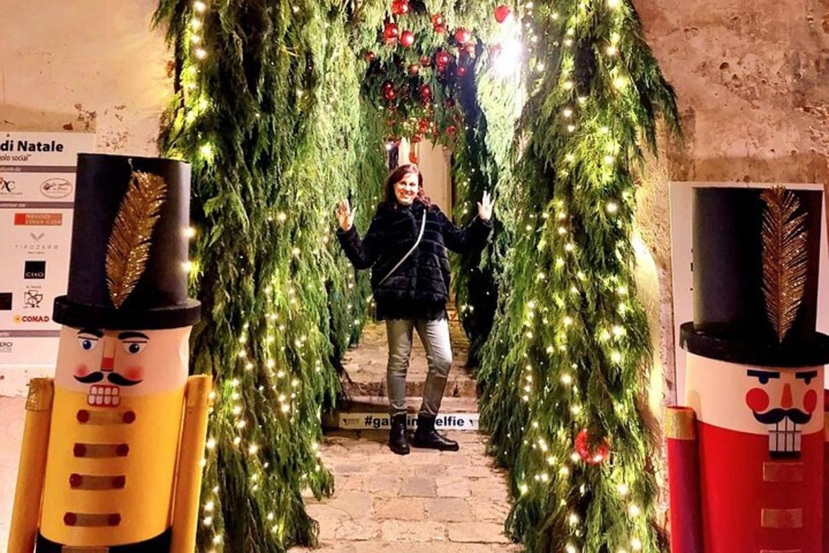 Una mujer está parada entre dos árboles de Navidad.