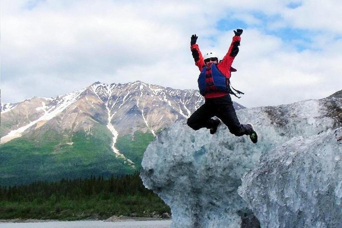 a man jumping off a rock with his hands in the air