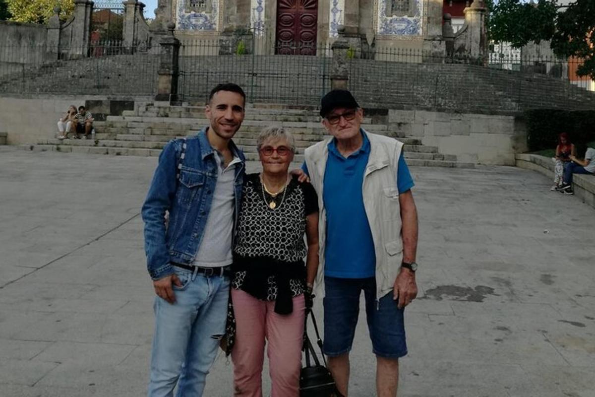 Dos hombres y una mujer de pie frente a un edificio.