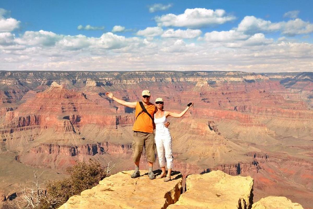 en mann og en kvinne som står på toppen av Grand Canyon
