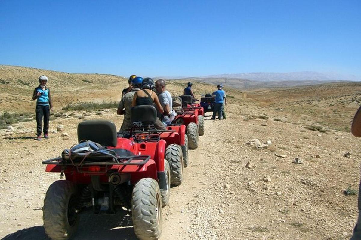 група људи који возе АТВ возила по земљаном путу
