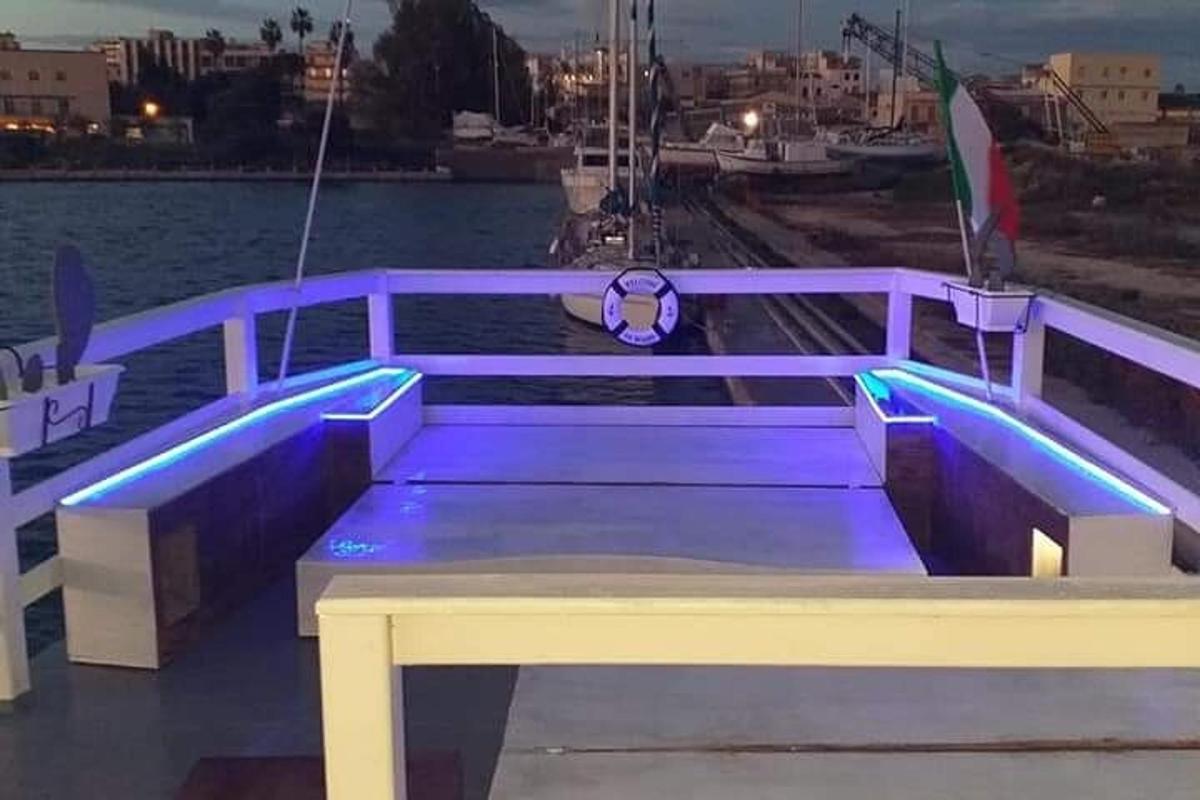 una panchina viola seduta su un molo vicino all'acqua