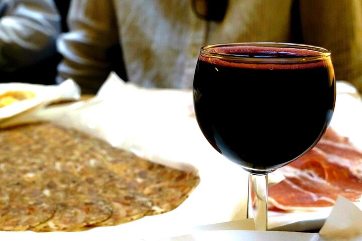 a glass of red wine sitting next to some food