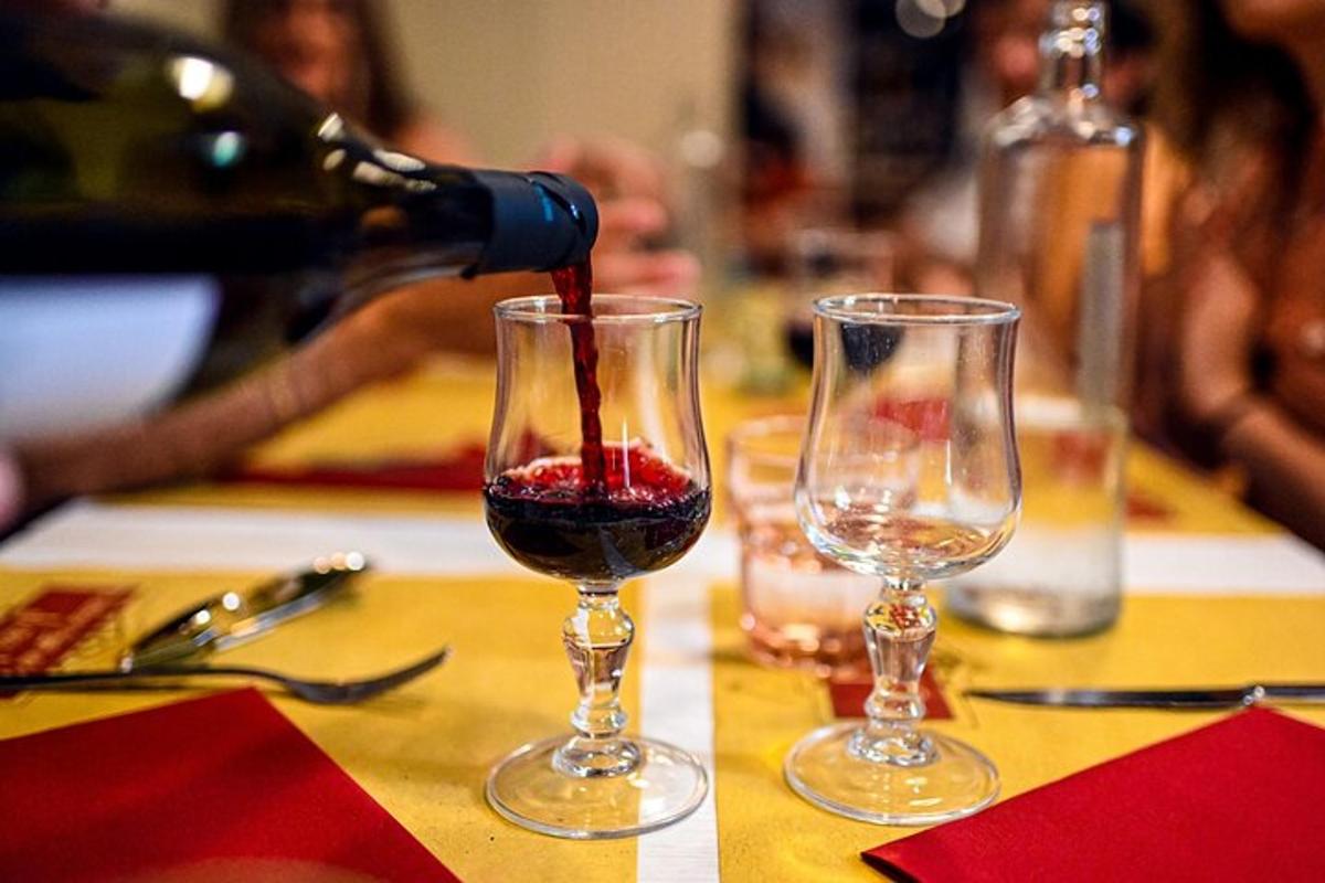 a person pouring wine into two wine glasses on a table