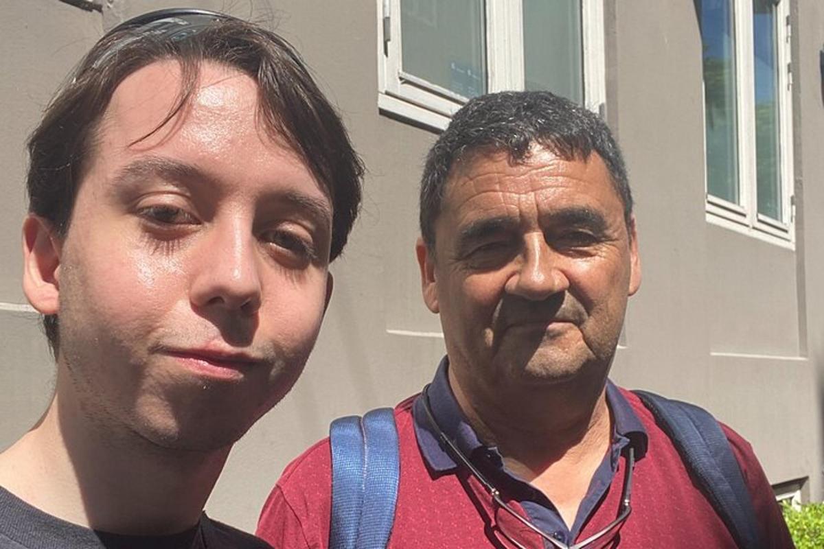 due uomini in piedi uno accanto all'altro davanti a una casa