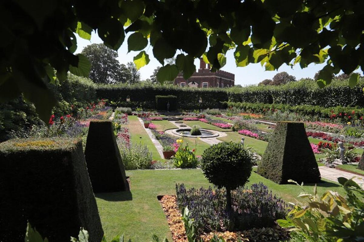 a garden with flowers and a fountain in the middle