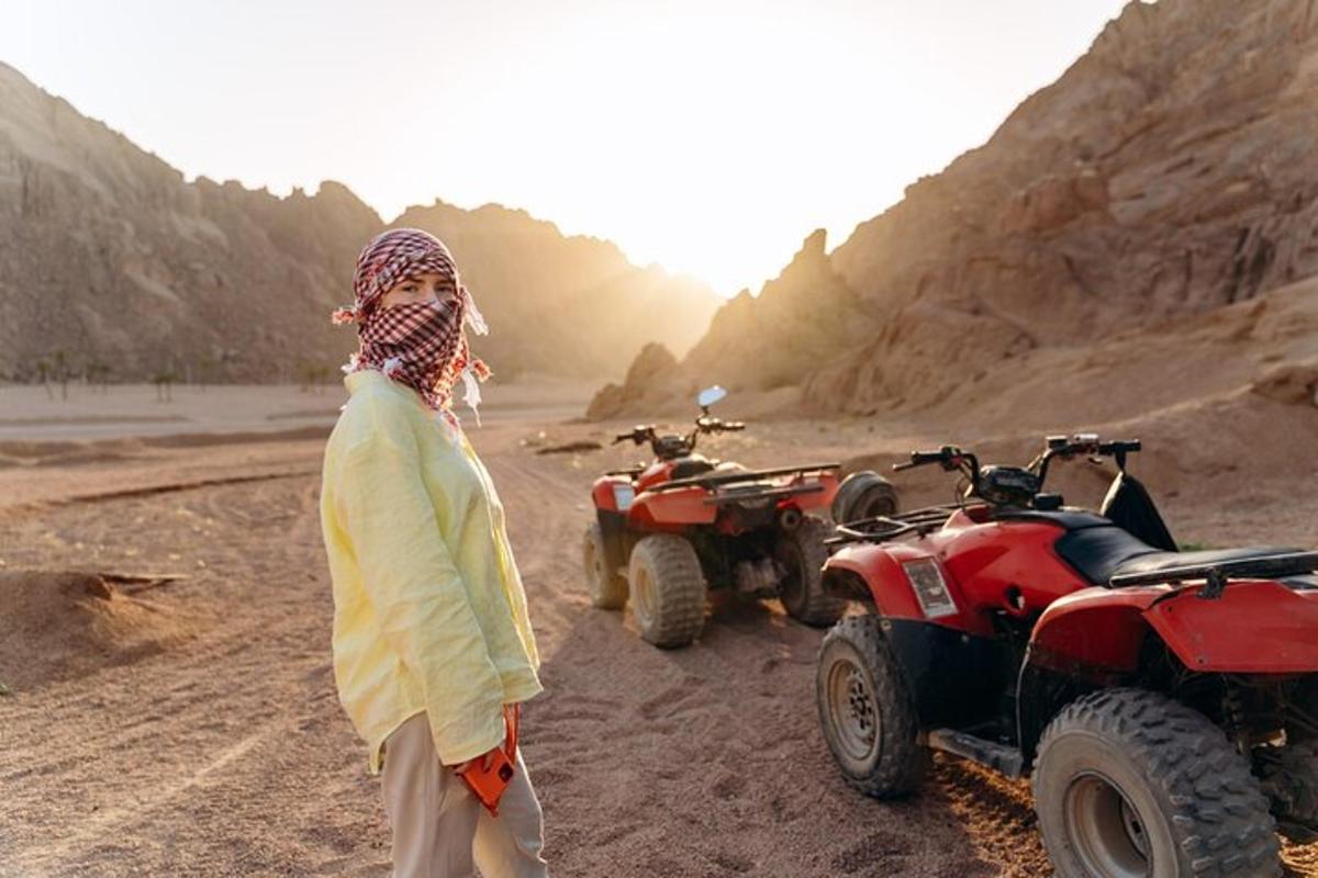 seorang wanita berdiri di padang pasir dengan dua atv