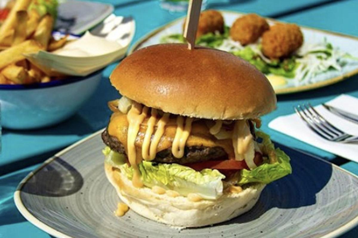 ein Cheeseburger auf einem Teller mit Pommes Frites