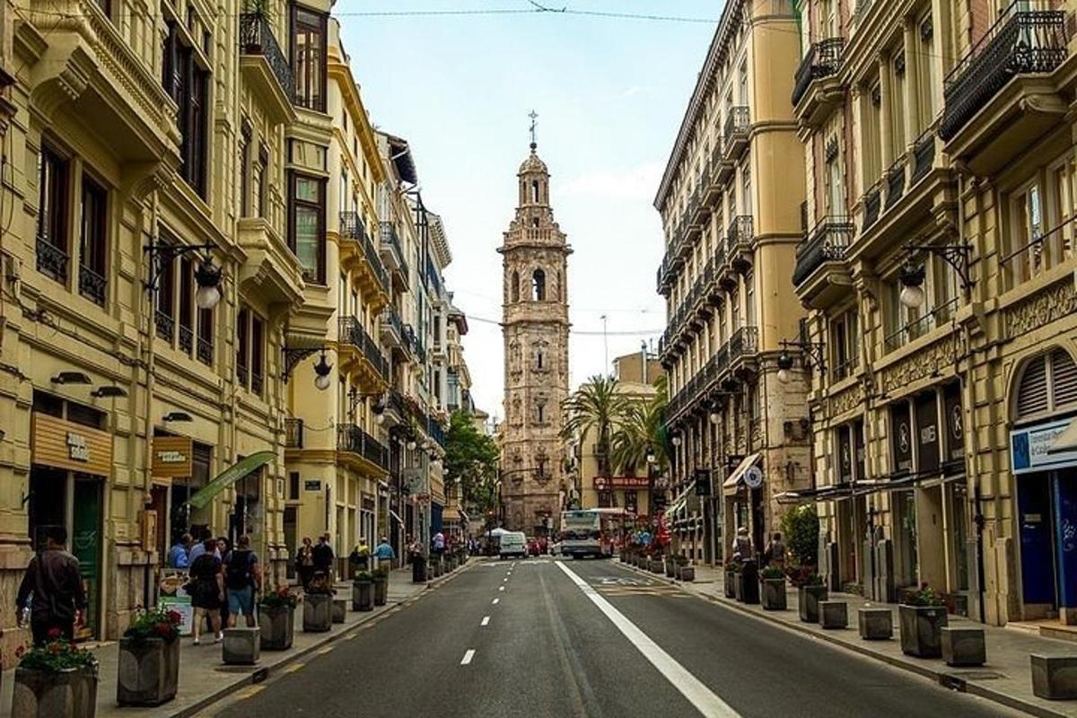 uma rua da cidade com uma torre do relógio ao longe