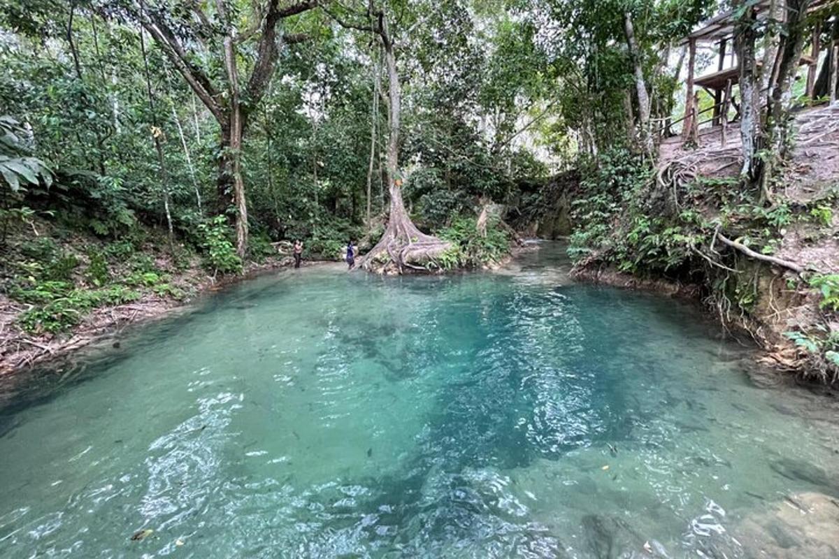 dua orang berdiri di dalam kolam air di sungai