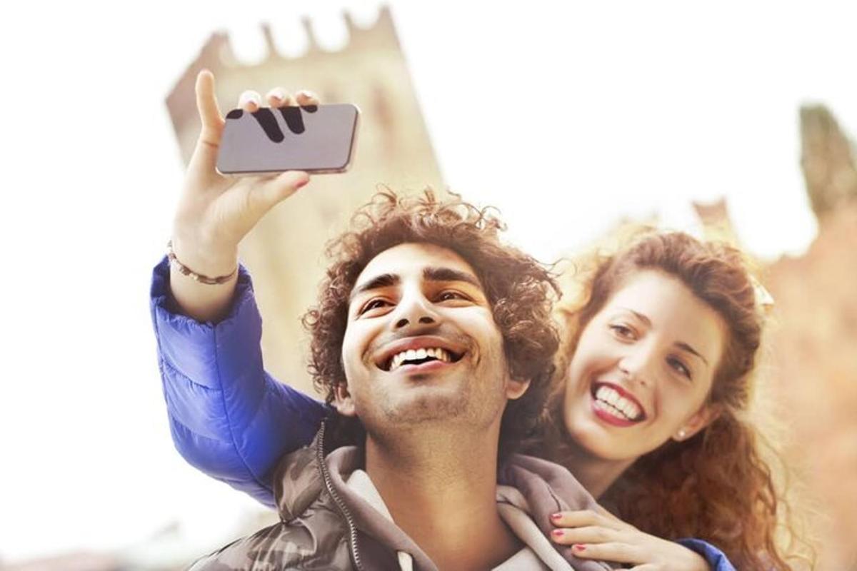 un home i una dona fent-se una foto amb un telèfon mòbil