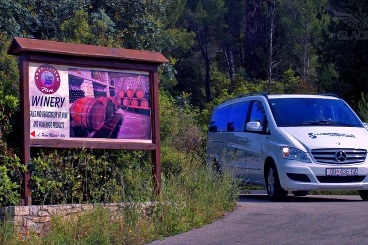 dodávka jedoucí po silnici vedle cedule