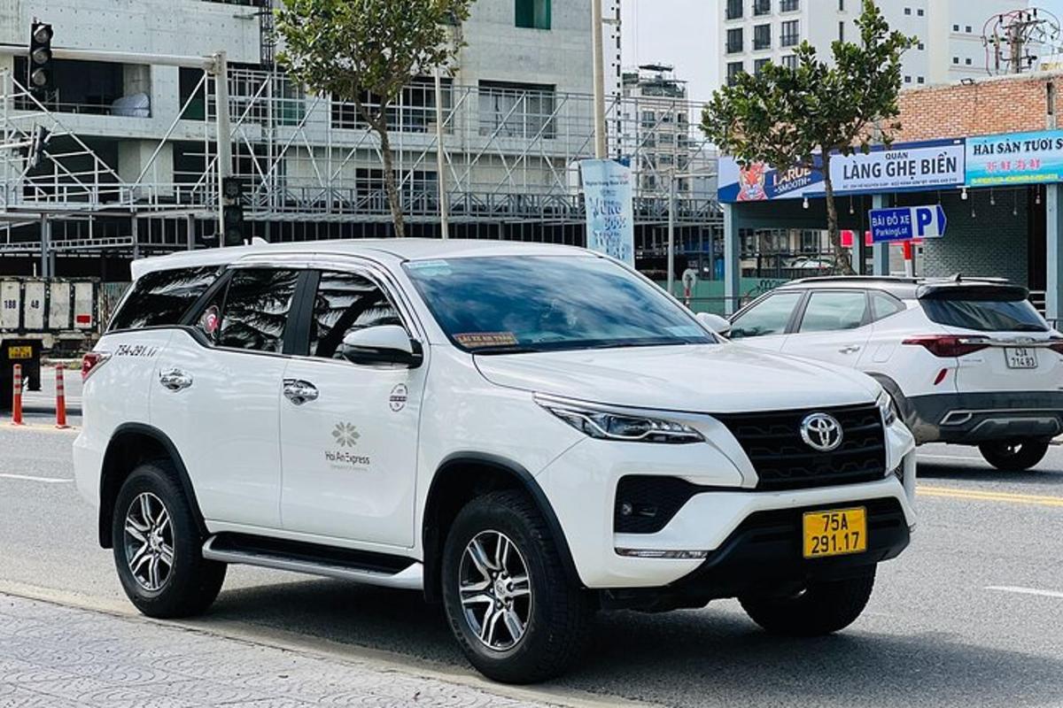 Bílá Toyota Fortuner jedoucí po městské ulici