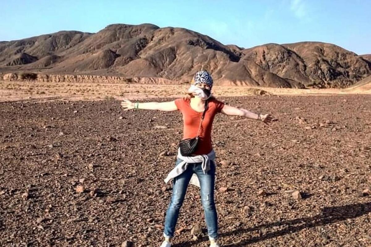 a woman in the desert with a dog on her head