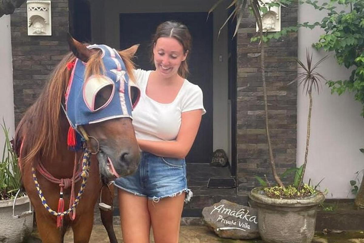 a young girl standing next to a horse