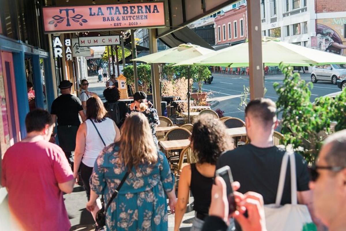a group of people walking down a sidewalk