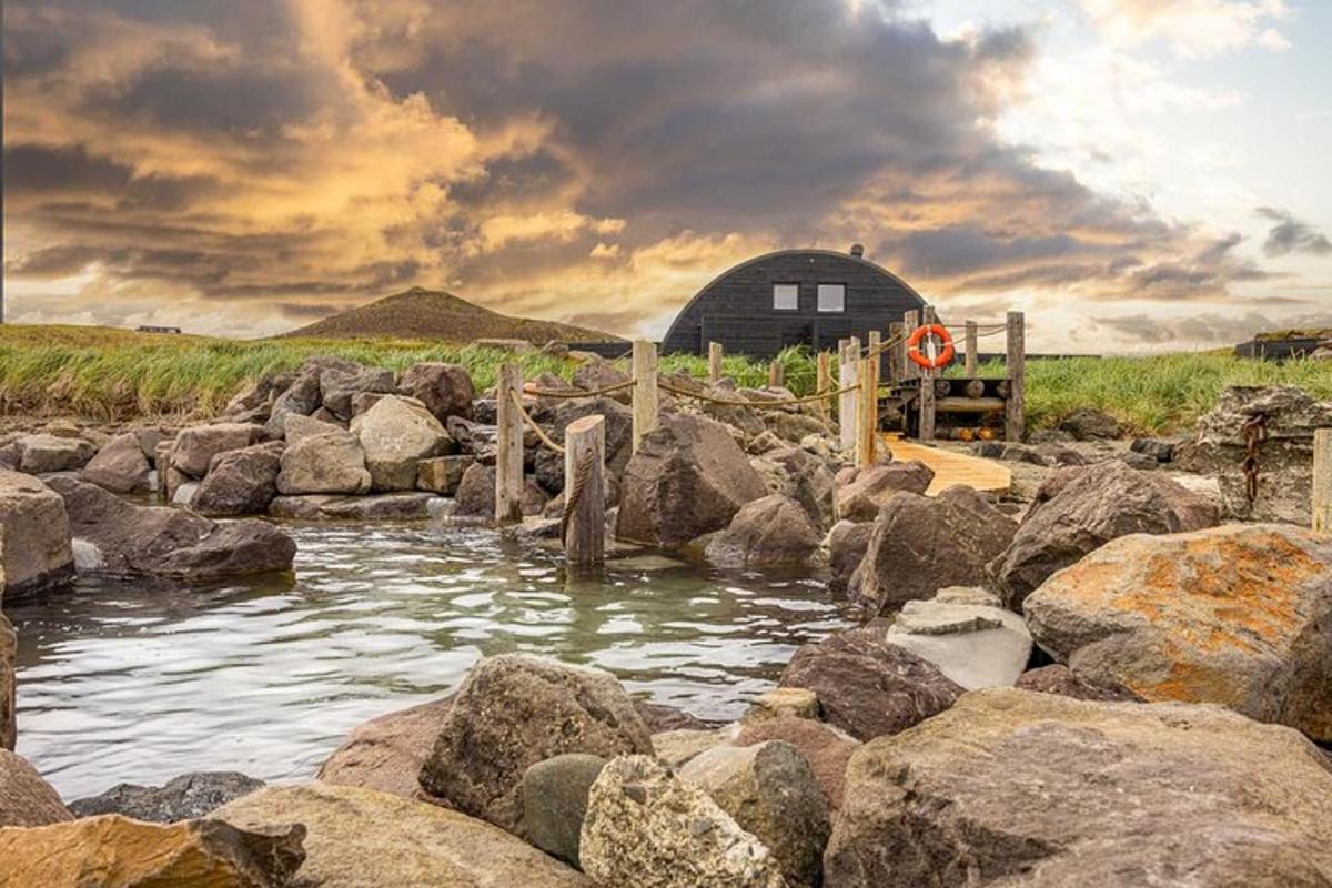 a river with rocks in front of a barn