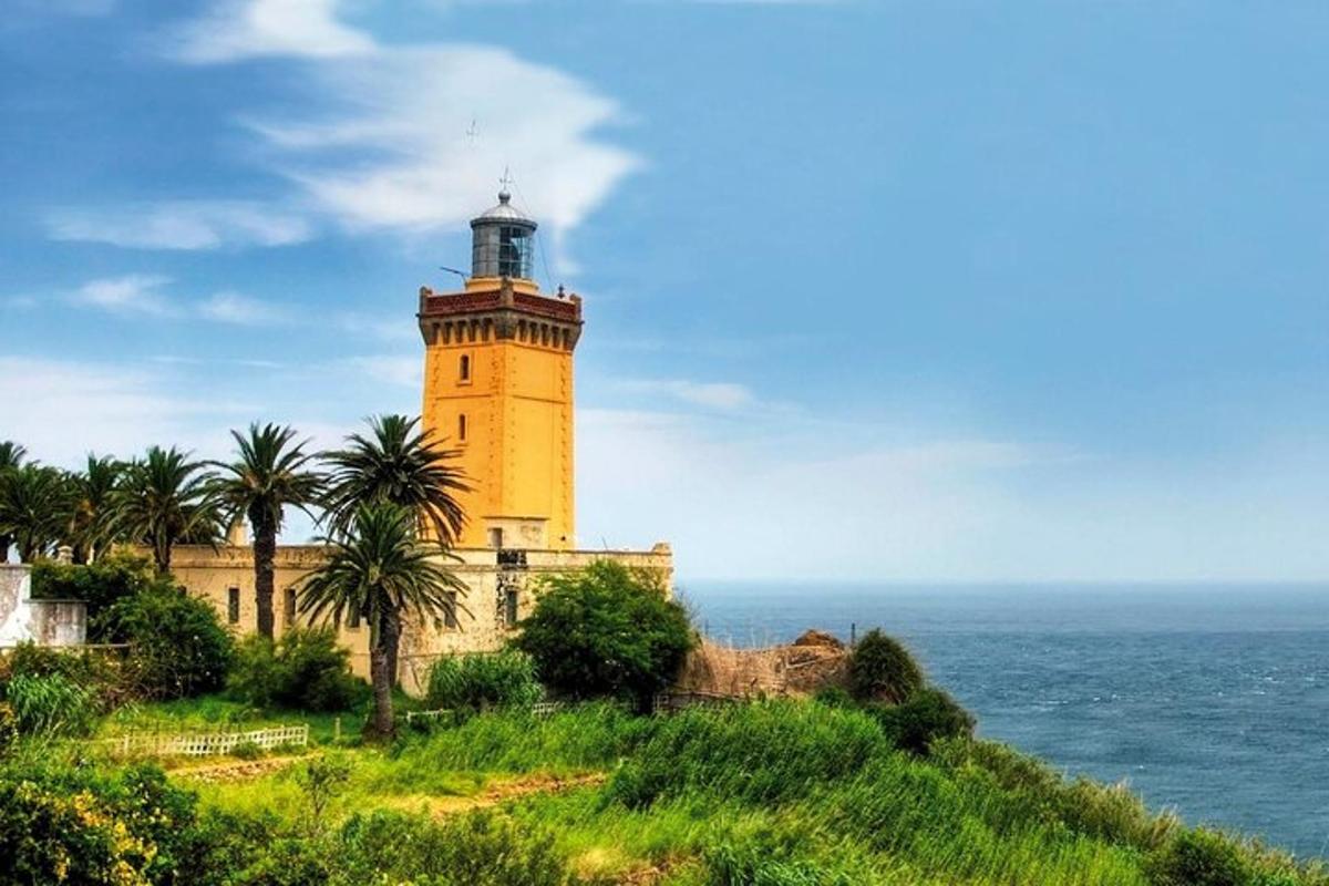 un phare sur une colline à côté de l'océan