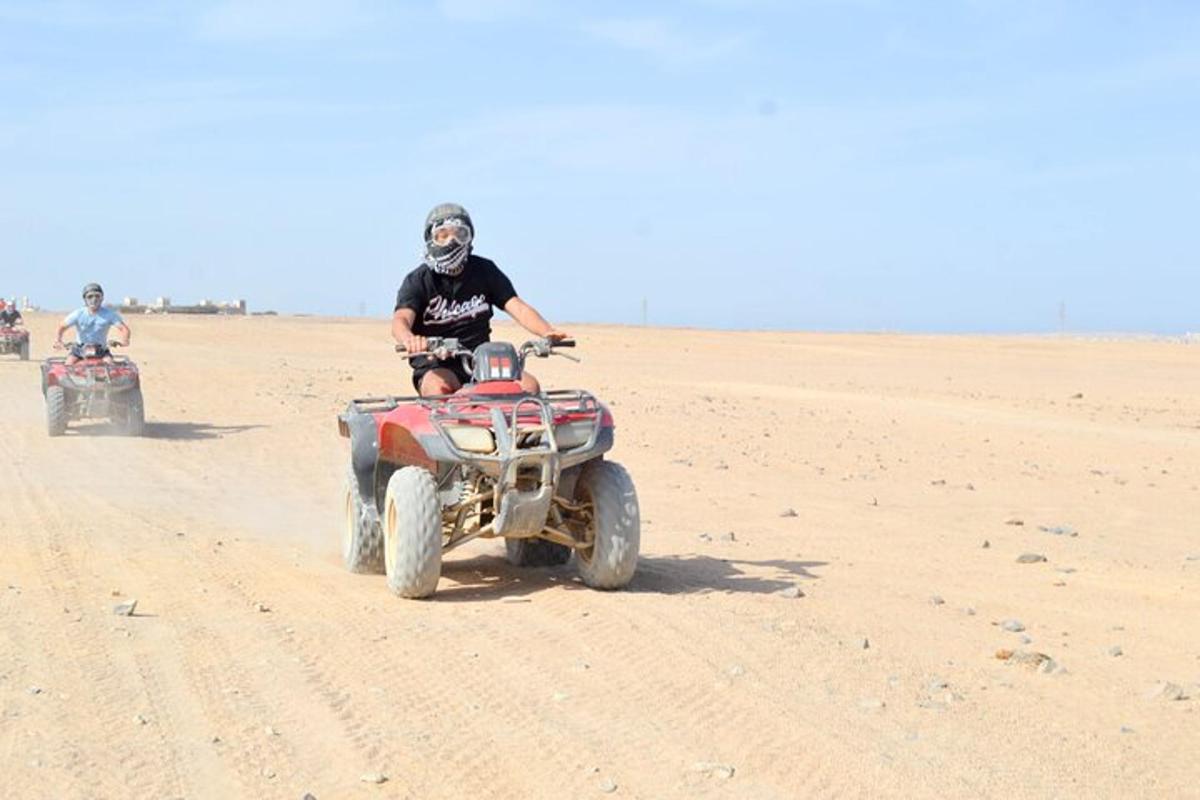 two people are riding atvs in the desert