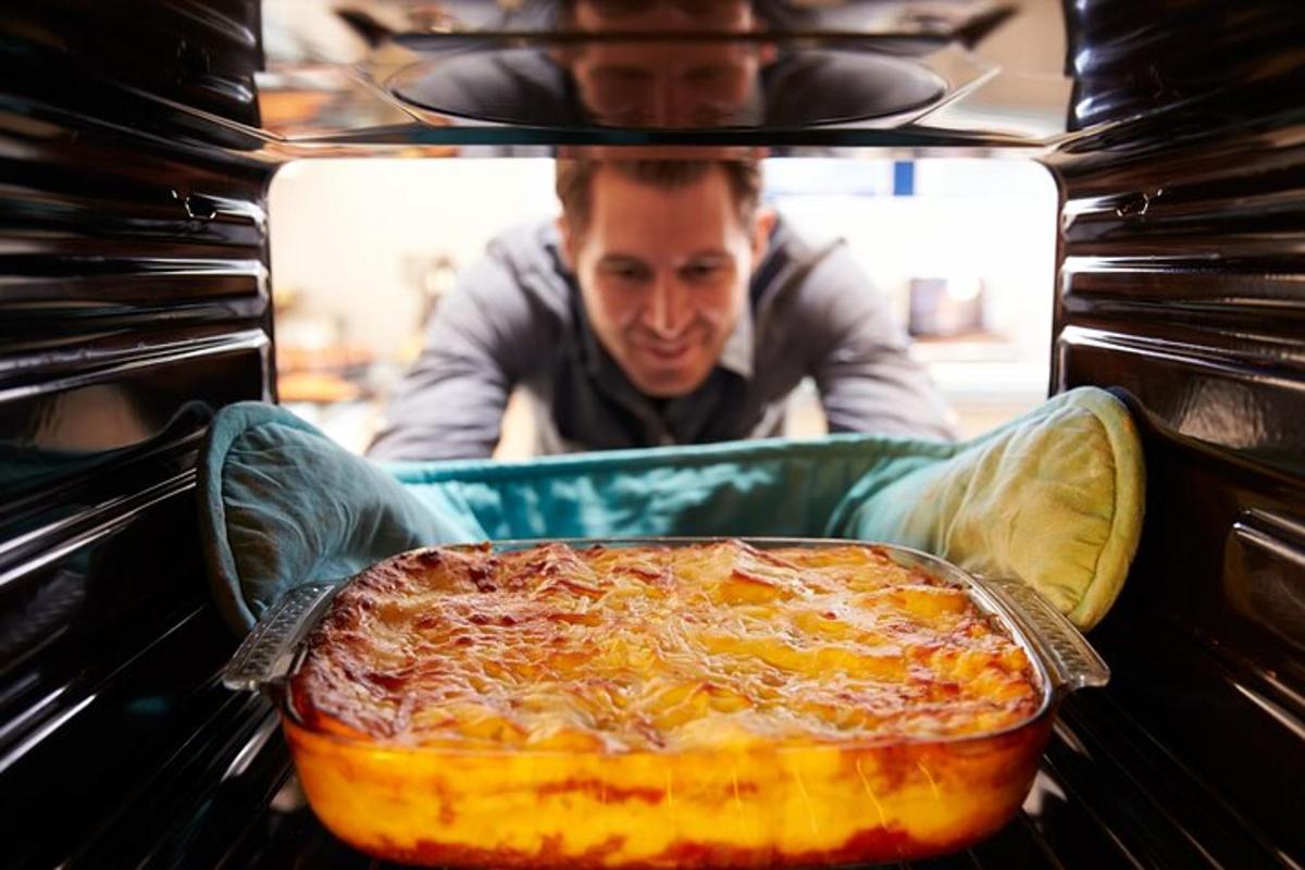 um homem está colocando uma pizza no forno