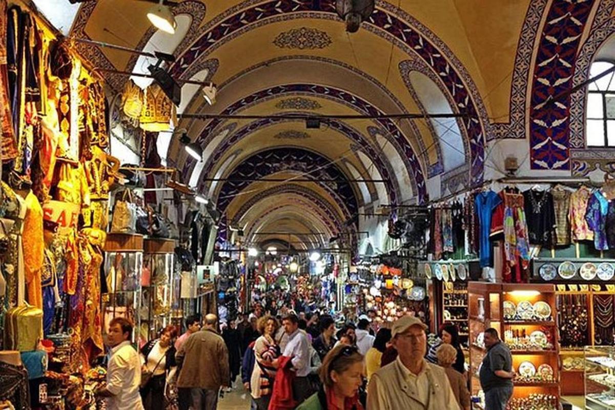 a crowd of people walking through a market in aazaar