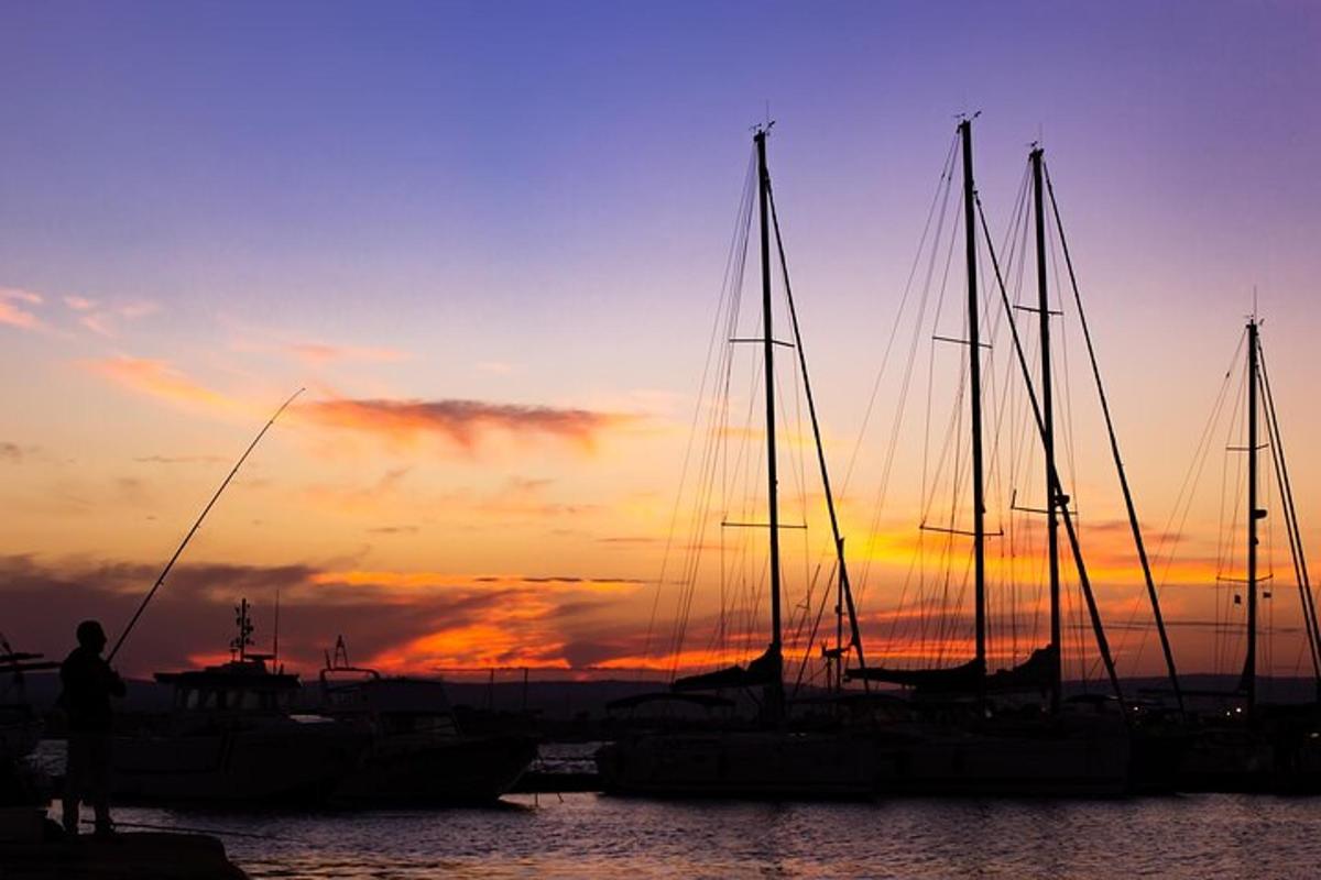 un gruppo di barche attraccate in un porto al tramonto